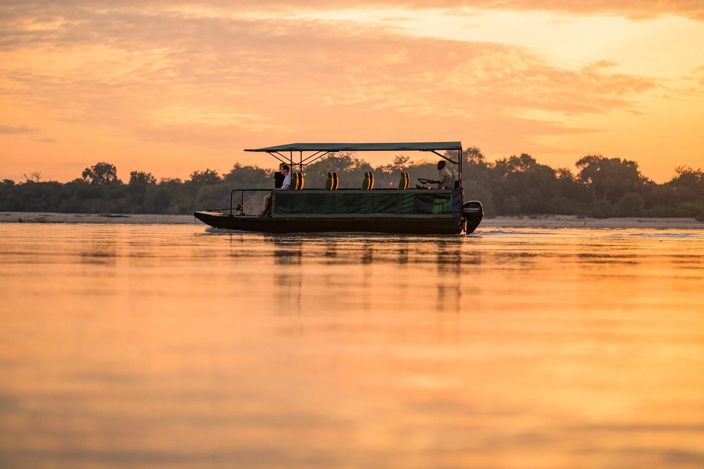 Boot überquert den Rufiji-Fluss bei Sonnenuntergang in der Nähe von Rufiji River Camp, Nyerere