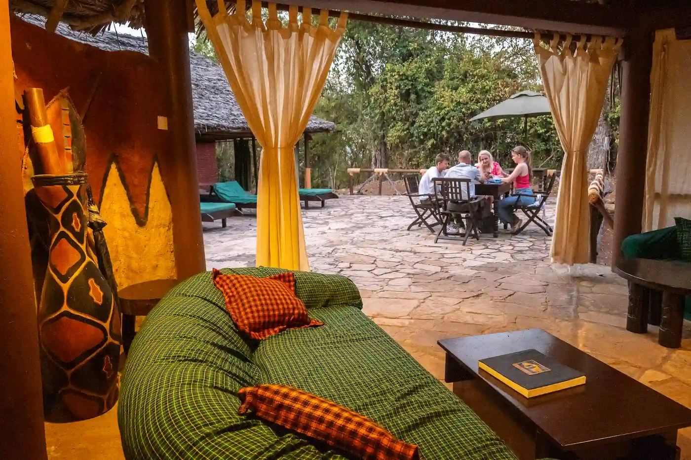 Loungen met gordijnen geven uit op een stenen terras van Sable Mountain Lodge.