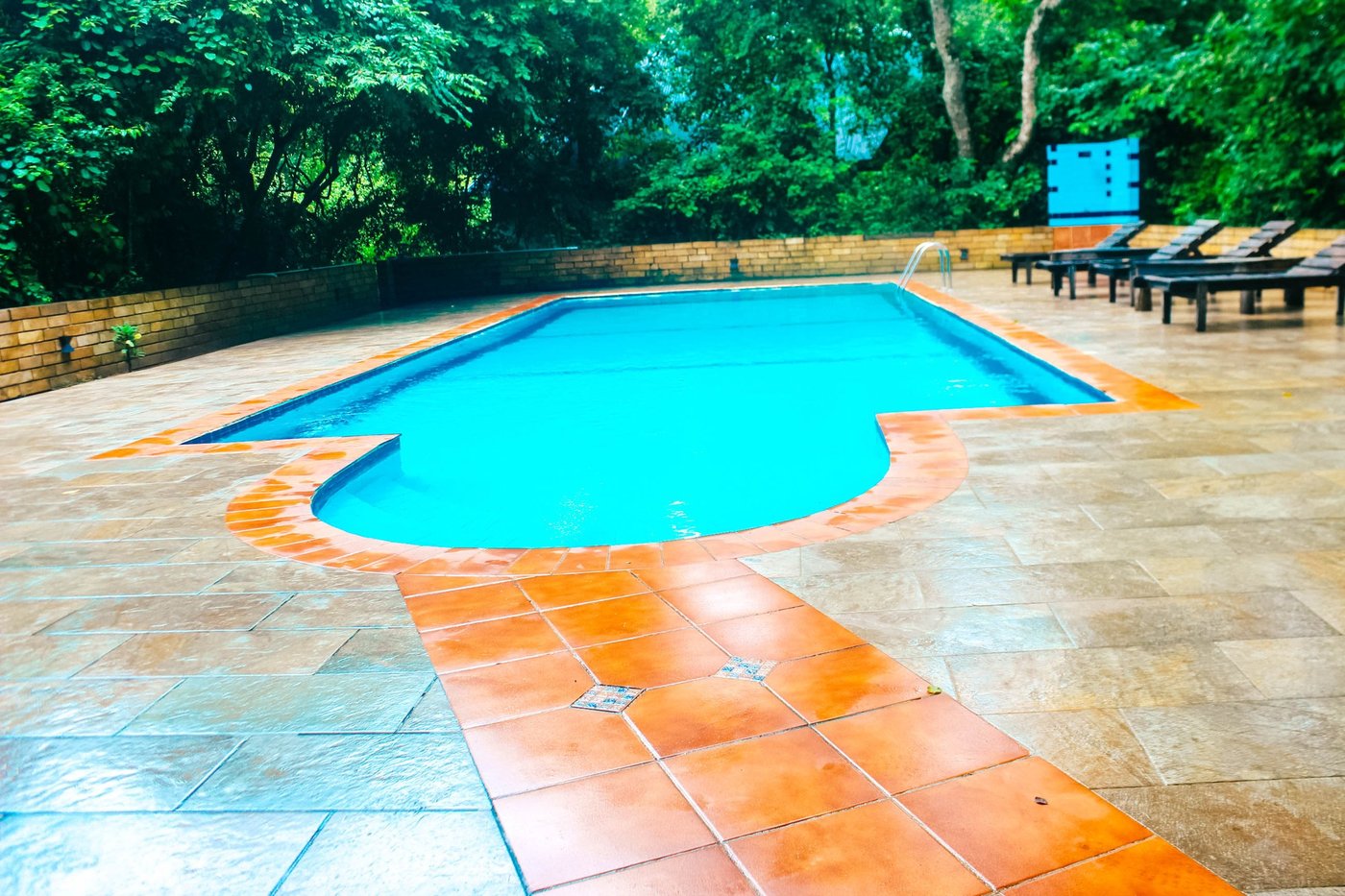 Swimmingpool und Liegestühle auf der Terrasse der Selous Kinga Lodge