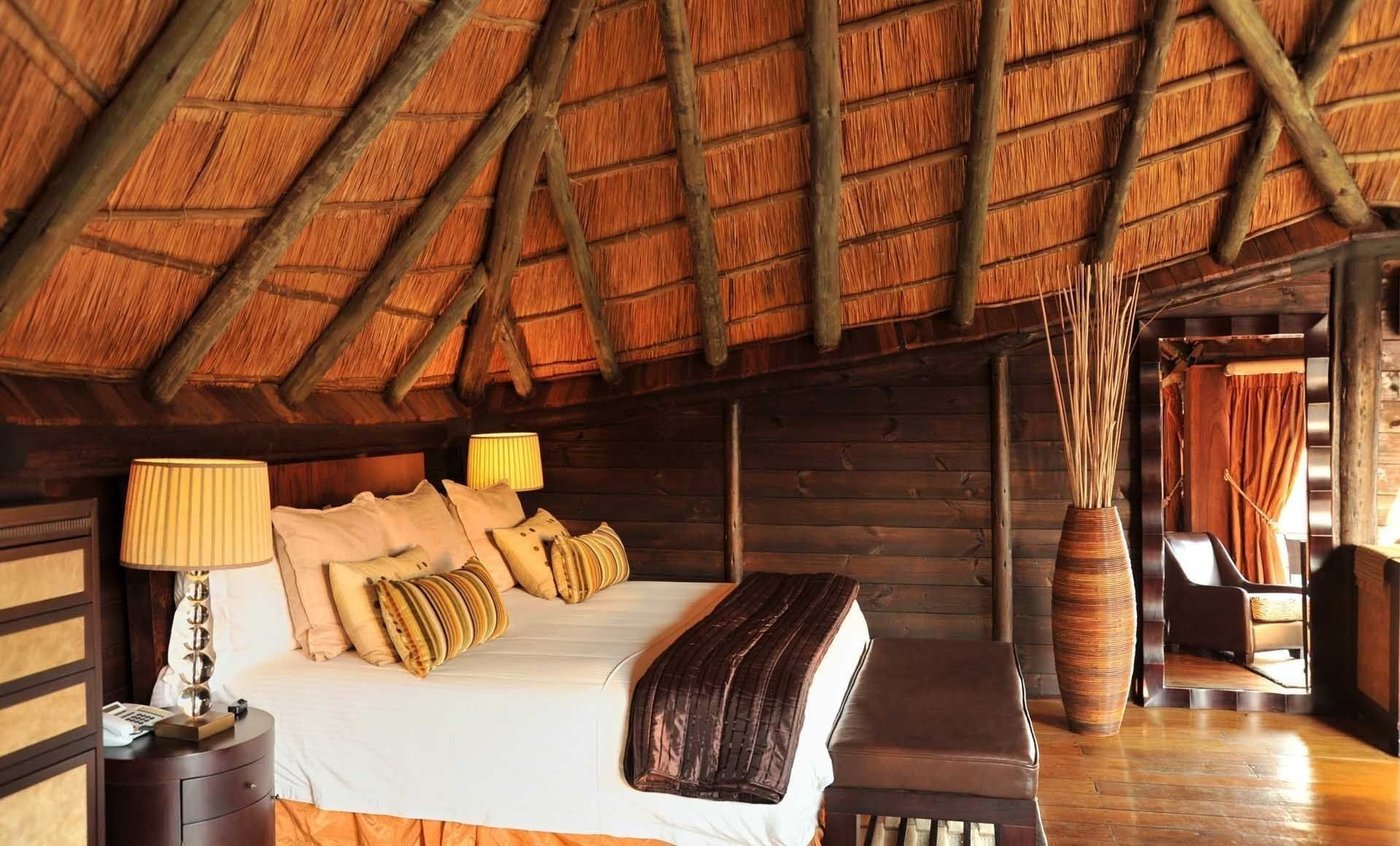 Chambre au toit de chaume avec terrasse face à la rivière au Serena Mivumo River Lodge