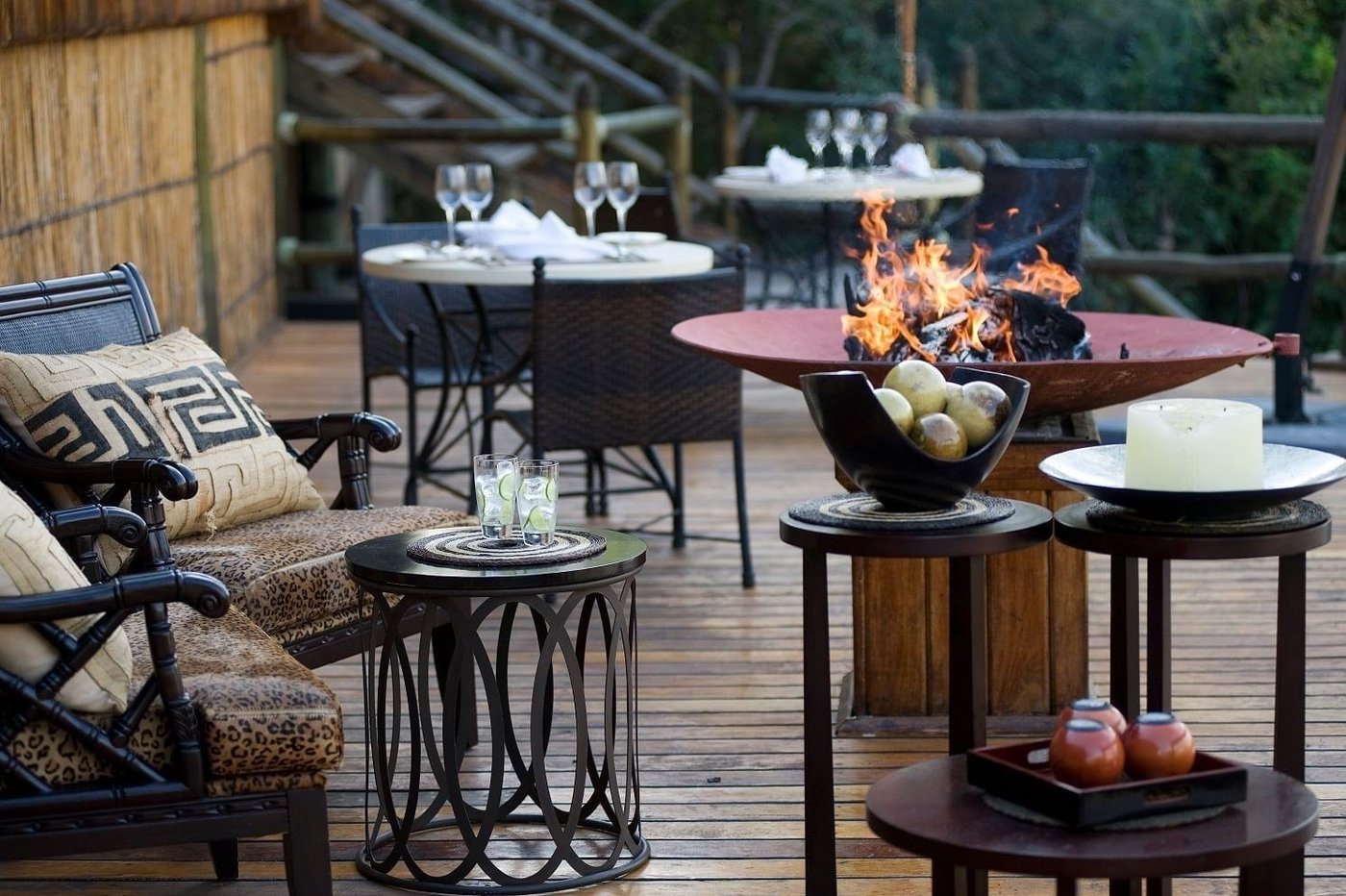 Terrasse de salle à manger extérieure avec un foyer au-dessus de la rivière au Serena Mivumo River Lodge